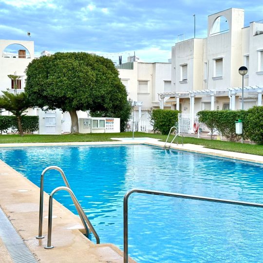 Piscina comunitaria gestionada por Orbital Group en complejo residencial de viviendas adosadas blancas